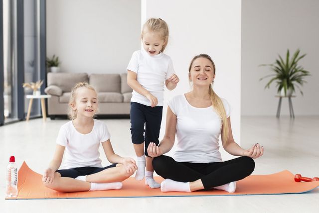 Mutter mit ihren Töchtern beim Yoga